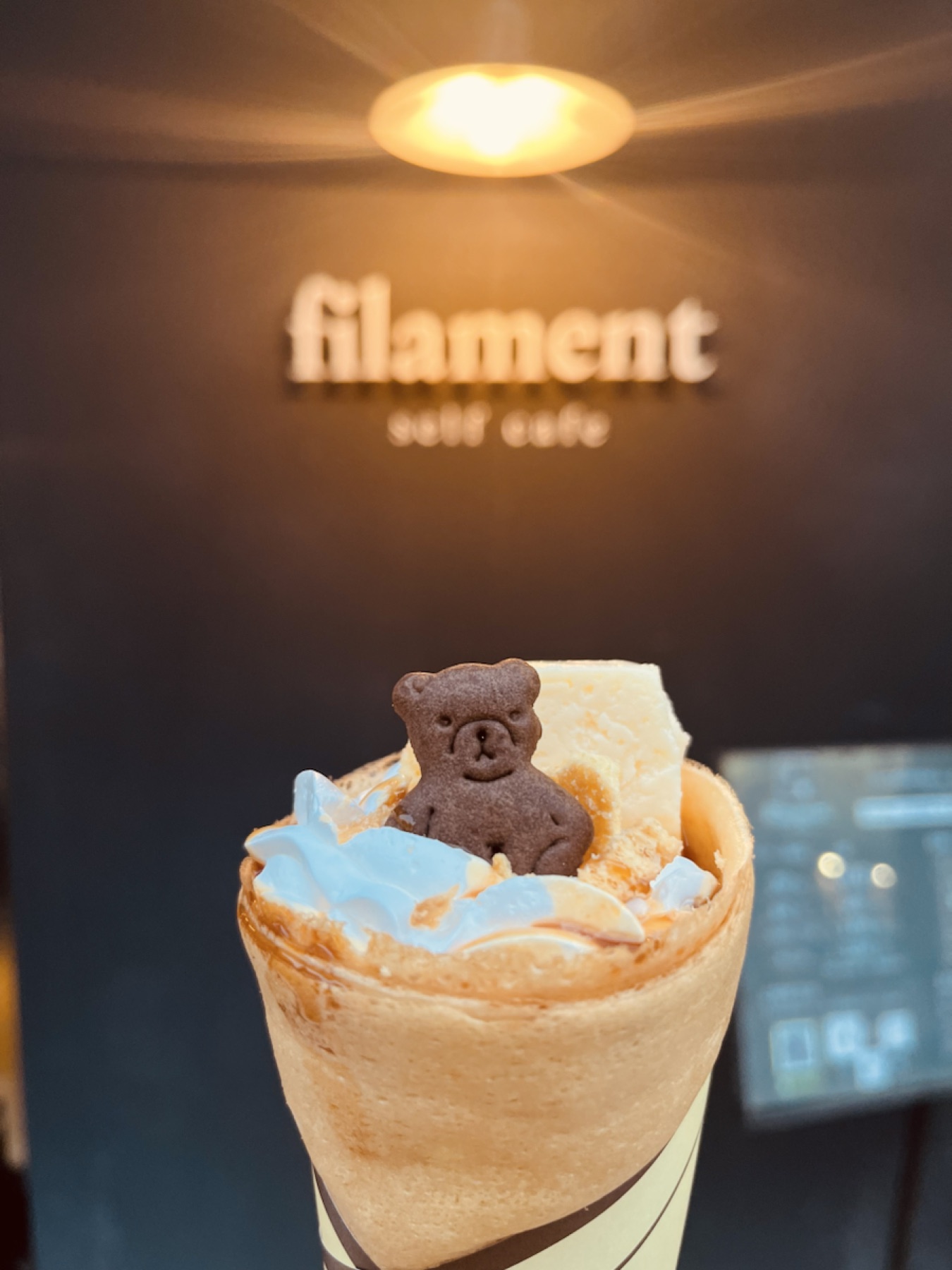 filament店内で楽しむ、くまのクッキーを飾ったキャラメルクレープ